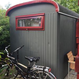 a bike parked in front of a shed with a window at Gipsy wagon near Amsterdam and beach in Velserbroek 