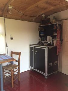 a kitchen with a stove and a table and a chair at Gipsy wagon near Amsterdam and beach in Velserbroek 