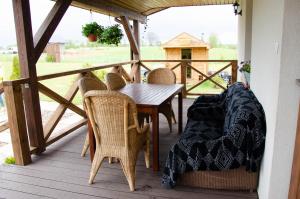 eine Holzterrasse mit einem Tisch und Stühlen auf einer Terrasse in der Unterkunft Domek Rospuda in Rospuda