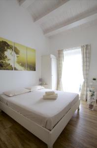 a white bedroom with a large bed with white sheets at B&B Vivere il Mare in Numana