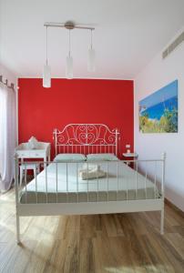 1 dormitorio con cama y pared roja en B&B Vivere il Mare, en Numana