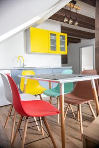 cocina con mesa y sillas coloridas en Apartmany pod Klingerom en Banská Štiavnica