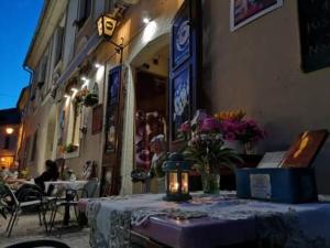 une table devant un bâtiment avec des fleurs dans l'établissement Afrodité Apartmanok, à Eger