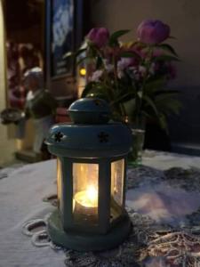 eine Kerze auf einem Tisch mit einer Blumenvase in der Unterkunft Afrodité Apartmanok in Eger