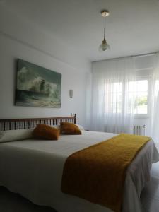 Un dormitorio con una gran cama blanca y una ventana en Hostal Pereiriña, en Cee