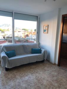 - un salon avec un canapé et une grande fenêtre dans l'établissement Beta's place - Apartamento primera línea de playa, à Blanes