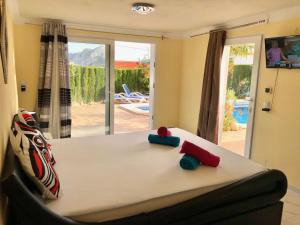 Un dormitorio con una cama con almohadas rojas y azules. en Villa HAYAHAY with PRIVATE POOL & Amazing view, en Calpe