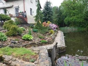 um jardim ao lado de uma casa com um lago em Izerski Poranek em Gryfów Slaski