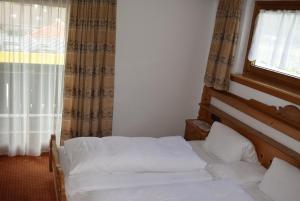 a bedroom with two beds in front of a window at Bergsteiger-Zimmer Pension Obermair in Mayrhofen