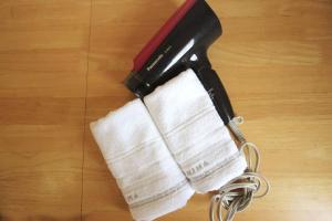 a hair dryer on a wooden floor with a towel at コーポアス in Nikko
