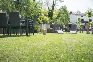 a group of chairs sitting on the grass in a yard at Apartment Vidus Wine Estate in Podnanos