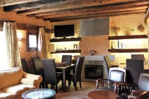 a living room with a table and chairs and a fireplace at El Rincón de Rascafría in Rascafría