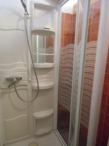 um chuveiro com uma porta de vidro na casa de banho em Hôtel De La Providence em Égliseneuve-dʼEntraigues