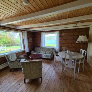 a living room with a table and chairs at Lysefjorden - Gøysa Gard in Forsand