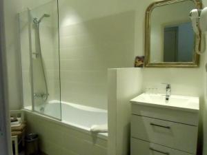 y baño con ducha, lavabo y bañera. en Hôtel De La Providence en Égliseneuve-dʼEntraigues