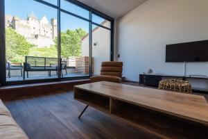a living room with a couch and a table and a tv at Le Loft de La Tour Pinte in Carcassonne