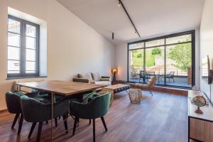 Le Loft de La Tour Pinte في قرقشونة: غرفة معيشة مع طاولة وكراسي خشبية