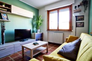 uma sala de estar com um sofá e uma televisão em Casa Zoe Apartment Free parking,self check in & free wi fi em Parma