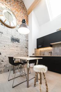 a dining room with a table and chairs and a brick wall at Le Cabri Ô Lait in Namur