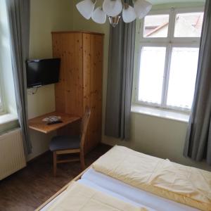 Schlafzimmer mit einem Bett, einem Schreibtisch und einem TV in der Unterkunft Gasthaus zum Lamm in Ettenheim