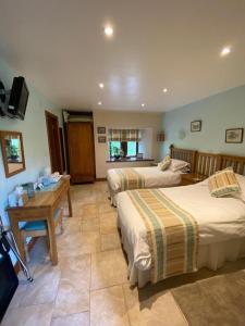 um quarto de hotel com duas camas e uma mesa em Broad Croft House em Horton in Ribblesdale