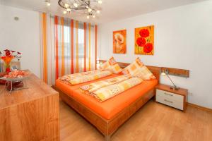 una camera da letto con un letto arancione con cuscini sopra di Business Suiten a Bochum