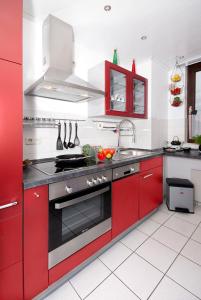 a kitchen with red cabinets and a stove top oven at Business Suiten in Bochum