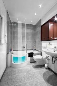 a bathroom with a tub and a toilet and a sink at Business Suiten in Bochum