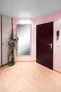 a pink room with a black door and a mirror at Business Suiten in Bochum