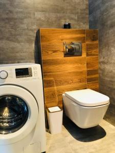 a bathroom with a washing machine and a toilet at Apartament Happiness in Jelenia Góra