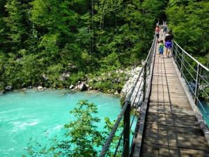 people on a suspension bridge over a river at Tiptop Apartment & Outdoor Activities in Bovec