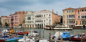 un groupe de bateaux amarrés dans un canal avec des bâtiments dans l'établissement Appartamenti Cà d'Oro, à Venise