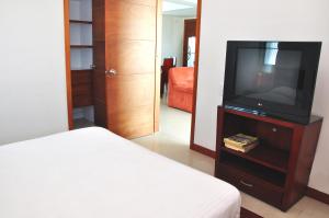 卡塔赫纳帕尔梅托卡塔赫纳Nª3401公寓的卧室里有一张床，梳妆台上放着一台电视。