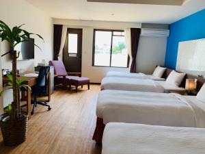 ein Hotelzimmer mit 4 Betten und einem Schreibtisch in der Unterkunft HiyagunLanaiResort in Okinawa