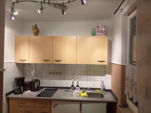 a kitchen with a sink and wooden cabinets at Bungalow 2 am Donnerberg in Sewekow in Sewekow