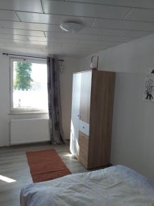 a bedroom with a bed and a dresser and a window at Bungalow 2 am Donnerberg in Sewekow in Sewekow