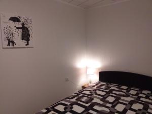 een slaapkamer met een bed en een lampje aan de muur bij Bungalow 2 am Donnerberg in Sewekow in Sewekow