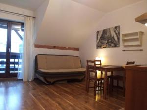 a living room with a couch and a table at Apartament Bronowice in Krakow