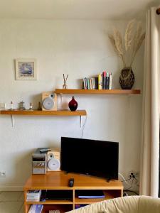 un soggiorno con una TV su un tavolo di legno di Pied à terre pour des vacances au bord de la mer a Le Conquet