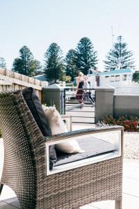 a wicker chair with pillows on a patio at The Waterfront Apartment in Port Fairy