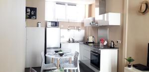 a kitchen with a small table and white appliances at Appartements Massena in Nice