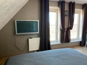 1 dormitorio con TV en la pared y 1 cama en Zoutelande,modern verblijf bij de zee, en Zoutelande