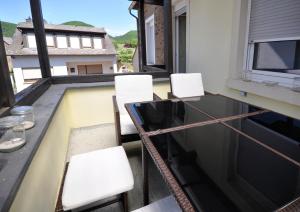 einen Balkon mit Stühlen, einem Tisch und einem Pool in der Unterkunft Fewo Steck in Bruttig-Fankel