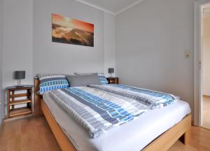 ein Bett mit einer blauen und weißen Bettdecke in einem Schlafzimmer in der Unterkunft Fewo Steck in Bruttig-Fankel