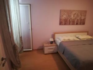 a small bedroom with a bed and a mirror at Apartments Roncevic in Zadar