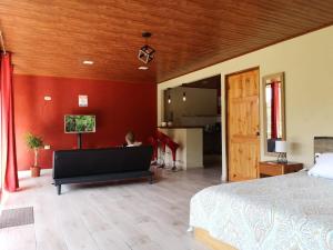 a person sitting on a bed in a bedroom at La Guayaba Monteverde in Monteverde Costa Rica