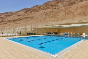 a large swimming pool with a mountain in the background at HI - Massada Hostel in Ein Bokek
