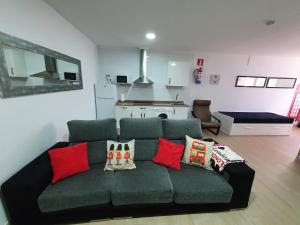 a living room with a green couch with red pillows at London - LA COLINA in San Miguel de Meruelo