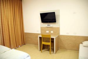 a room with a desk with a tv and a chair at HI - Massada Hostel in Ein Bokek