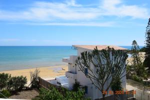 a building next to a beach with the ocean at A mmari semu - Scala dei Turchi in Realmonte